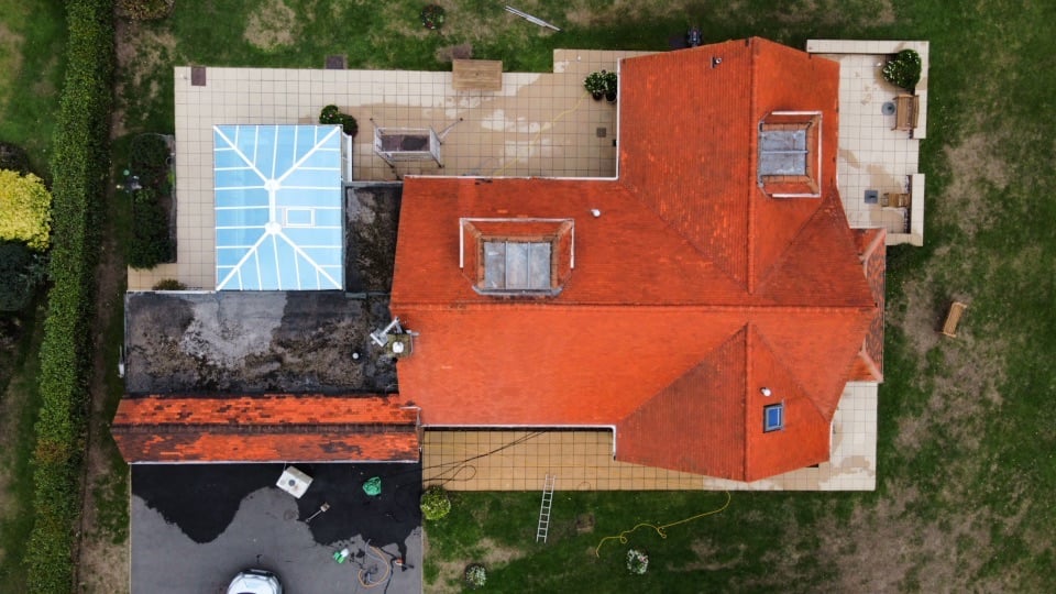 The same roof photographed from the same angle after moss removal and soft washing